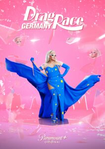Barbie Breakout als Hostin von Drag Race Germany Staffel 1 in einem royalblauen Kleid vor pinkem Hintergrund. Über ihr das Logo von Drag Race Germany